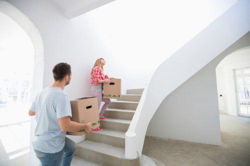 Team unloading boxes and furniture at a new home in Maidavale